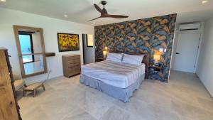a bedroom with a bed and a ceiling fan at Stunning seaside villa with pool and jacuzzi in Boca Chica +25 photos
