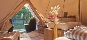 a living room with a tent with a vase of flowers at Glamping auf dem Weberhof in Münster +23 photos
