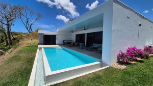 a swimming pool in the backyard of a house at Stunning seaside villa with pool and jacuzzi in Boca Chica