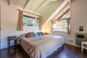 a bedroom with a bed in a room with windows at INDÓMITO HOSTEL in San Carlos de Bariloche