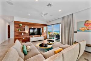 a living room with a couch and a tv at Skyline Villas - Villa Skyline with stunning Ocean View in Providenciales