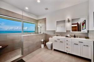 a bathroom with a sink and a toilet and a window at Skyline Villas - Villa Skyline with stunning Ocean View in Providenciales