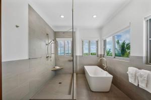 a white bathroom with a tub and a sink at Skyline Villas - Villa Skyline with stunning Ocean View in Providenciales +30 photos