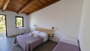 a bedroom with two beds and a desk in it at Locanda Adele in Parghelia