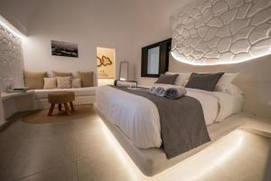 a bedroom with a large white bed and a couch at Rosaviglia Luxury Villa - an Oia Private Hideaway in Oia