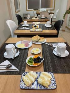 a group of tables with plates of food on them at Hostal Casa Arrayán in Coihaique