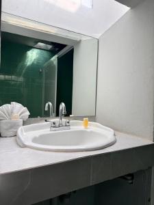 a sink in a bathroom with a large mirror at Hotel Casa 22 in San Miguel de Allende