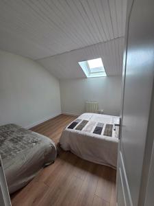a bedroom with a bed and a skylight at La liberté des trois petits cochons avec spa in Lalizolle