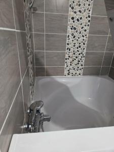 a white bath tub with a faucet in a bathroom at La liberté des trois petits cochons avec spa in Lalizolle +5 photos