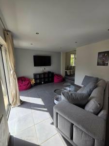 a living room with a couch and a flat screen tv at La liberté des trois petits cochons avec spa in Lalizolle