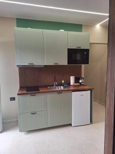 a kitchen with white cabinets and a sink and a microwave at Smarthome Boutique, Collegno in Collegno