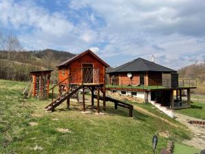 a log cabin with a playground and a house at Chata Exit in Kolonica