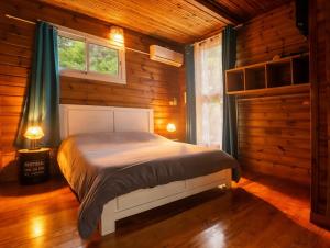 a bedroom with a bed in a log cabin at Bunga-lodge VANILLE in Saint-André