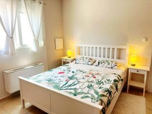 a bedroom with a bed with a floral bedspread at Bougainvillea Retreat above Faliraki in Kalithies