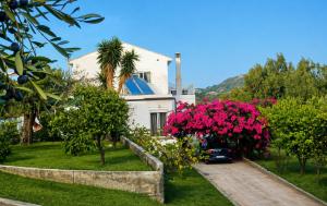 a white house with pink flowers in front of it at Bougainvillea Retreat above Faliraki in Kalithies