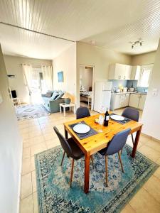 a living room with a wooden table and chairs at Bougainvillea Retreat above Faliraki in Kalithies