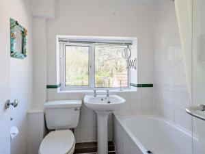 a white bathroom with a toilet and a sink at 4 Bed in Wareham oc-dc204 in East Stoke +15 photos