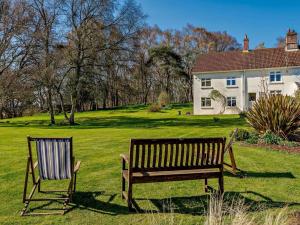 a bench and a chair in front of a house at 4 Bed in Wareham oc-dc204 in East Stoke
