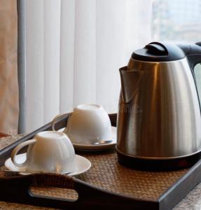 a tea kettle and two cups on a tray at Tamu Kyi Retreat in Kaluk
