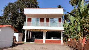 a white and red house with a balcony at Lotus Leaf Resort, Murud in Murūd +11 photos