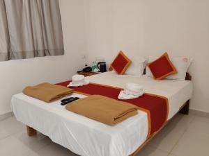 two beds in a hotel room with towels on them at Lotus Leaf Resort, Murud in Murūd