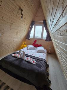 a bedroom with a bed in a wooden house at Elioan Cozy A-Frame in Mărăcineni +41 photos