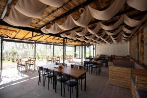 a dining room with tables and chairs and windows at The Barrels Ms in Gjirokastër
