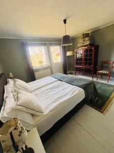 a bedroom with a large bed and a chair at Chilla villa in Leryd