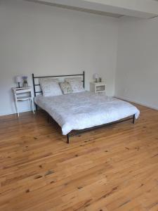 a bed in a room with a wooden floor at La maison de la Loue in Lods +7 photos