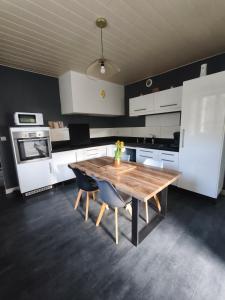 a kitchen with a wooden table and two chairs at La maison de la Loue in Lods