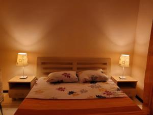 a bedroom with a bed with two lamps on it at Bosco Dream Neptun-Olimp in Neptun