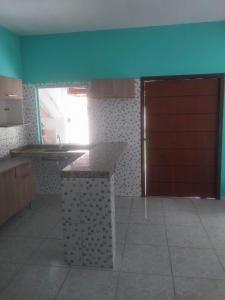 a kitchen with a counter and a red door at casa pescador centro in Porto Seguro
