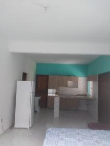 a kitchen with a white refrigerator in a room at casa pescador centro in Porto Seguro +1 photo