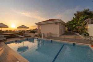 a swimming pool in front of a house at Vereniki Apartments in Finikounta