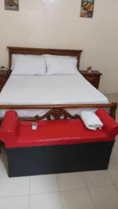 a red and black bed with a white mattress at RÉSIDENCE KFS bTp in Tambacounda
