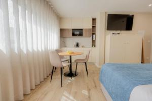 a bedroom with a table and chairs next to a bed at Calvário Suites II in Chaves