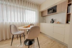 a kitchen with a table and chairs in a room at Calvário Suites II in Chaves
