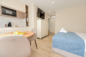 a kitchen and dining room with a table and chairs at Calvário Suites II in Chaves