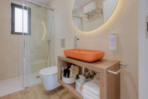 a bathroom with a sink and a toilet and a mirror at Calvário Suites l in Chaves