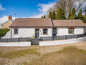 a white cottage with a fence in front of it at 1 Bed in New Moat oc-77692 in New Moat