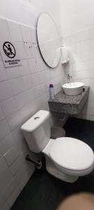 a bathroom with a toilet and a sink and a mirror at Cuba Linda Capsule Stay in Asunción +14 photos