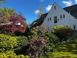 a white house with trees and flowers in the yard at CarMichael in Edinburgh
