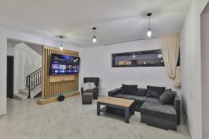 a living room with a couch and a tv at Pe Coastă in Cozăneşti
