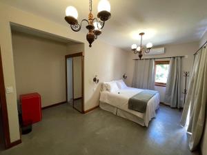 a bedroom with a bed and a chandelier at Pouso Alvorada in Tiradentes