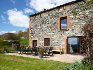 a stone building with tables and chairs in front of it at 8 Bed in Cumbria oc-sz373 in Applethwaite