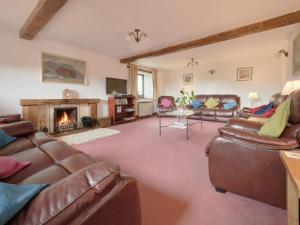 a living room with leather furniture and a fireplace at 8 Bed in Cumbria oc-sz373 in Applethwaite