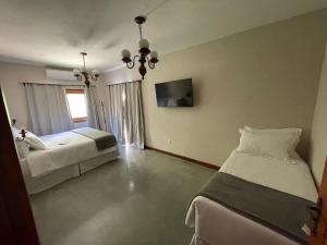 a bedroom with two beds and a flat screen tv at Pouso Alvorada in Tiradentes
