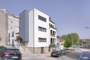 a white building on the side of a street at Calvário Suites l in Chaves
