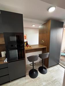 a kitchen with two bar stools and a microwave at Delux apartments in Gornji Milanovac