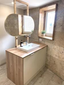 a bathroom with a sink and a mirror at Le Barral in Voiron
